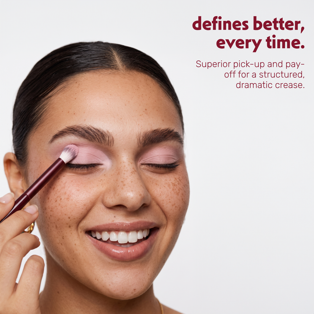Un modèle applique du fard à paupières dans le creux de la paupière avec le Boozyshop Flawless Defined Crease Brush