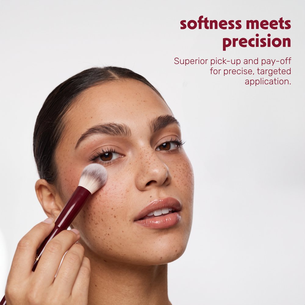 Un modèle applique de la poudre sur le visage avec le Boozyshop Flawless Precision Powder Brush